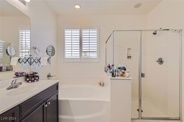 bathroom featuring vanity and independent shower and bath