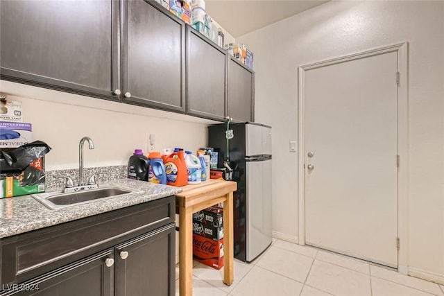 laundry room with sink and light tile patterned floors