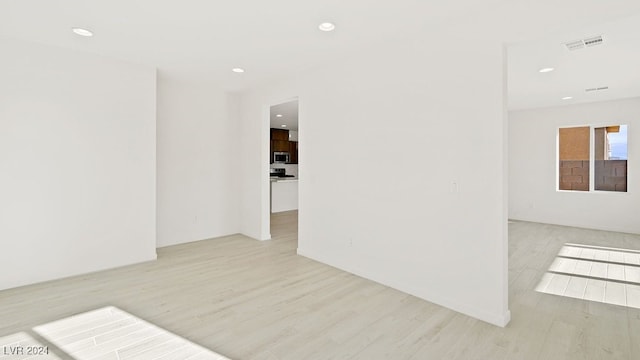 spare room featuring recessed lighting, visible vents, and wood finished floors