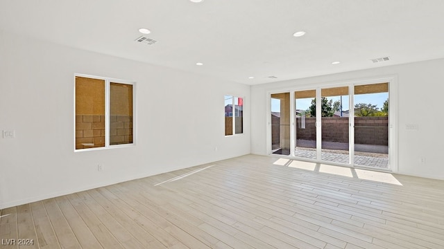 empty room with light wood-type flooring, visible vents, and recessed lighting