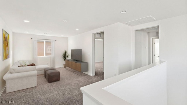 carpeted living room with visible vents, baseboards, and recessed lighting