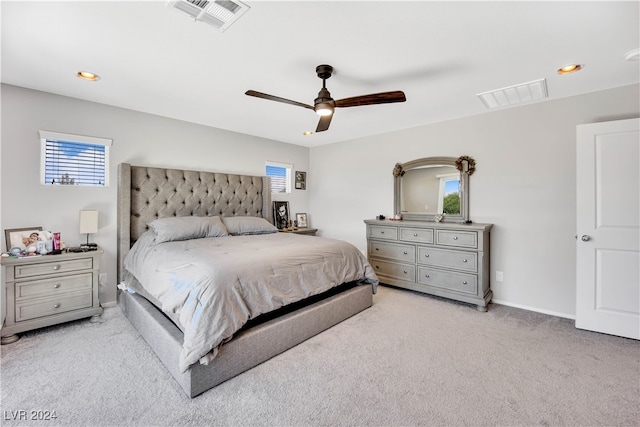 bedroom with ceiling fan, multiple windows, and light carpet