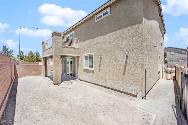 rear view of property with a patio area and a balcony