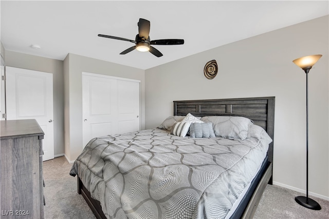 bedroom featuring ceiling fan, a closet, and light colored carpet