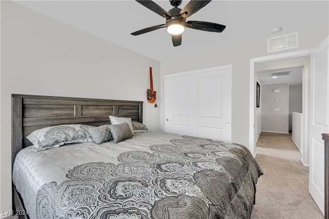 carpeted bedroom with ceiling fan and a closet