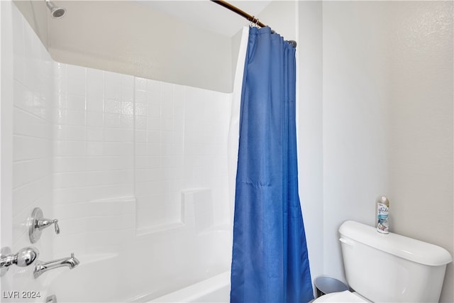 bathroom featuring toilet and shower / bath combination with curtain