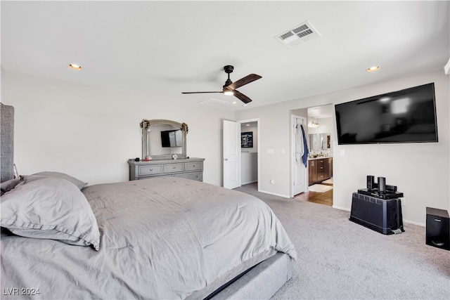 bedroom with ceiling fan, ensuite bath, and carpet flooring