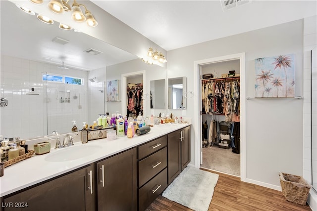 bathroom with hardwood / wood-style floors, dual bowl vanity, and an enclosed shower