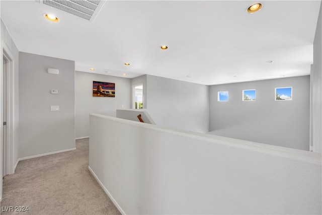 hallway with light carpet and a wealth of natural light