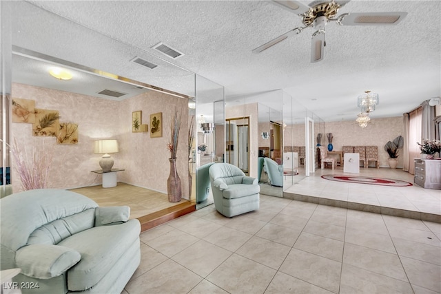 living room featuring a textured ceiling, light tile patterned floors, and ceiling fan