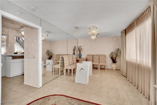 tiled dining room featuring ceiling fan and a textured ceiling