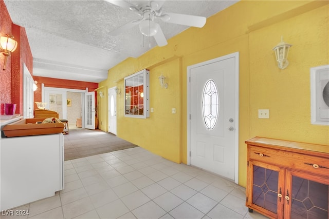 foyer with ceiling fan, light tile patterned flooring, and a textured ceiling