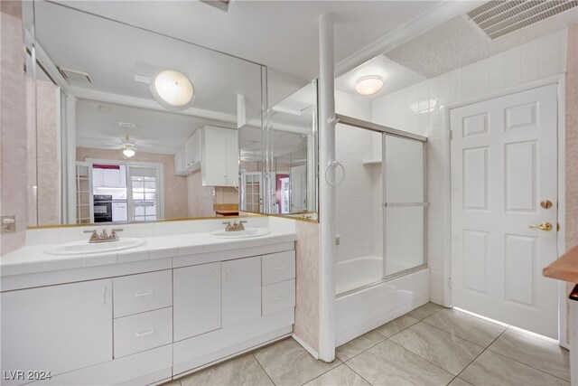 bathroom with ceiling fan, shower / bath combination with glass door, dual vanity, and tile patterned flooring