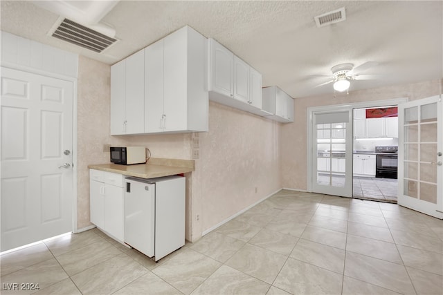 kitchen with french doors, light tile patterned flooring, ceiling fan, white cabinets, and stove