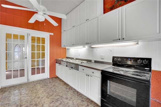 kitchen featuring tasteful backsplash, black electric range oven, light tile patterned flooring, ceiling fan, and white cabinets