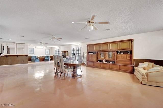 dining space with a textured ceiling, light tile patterned floors, and ceiling fan