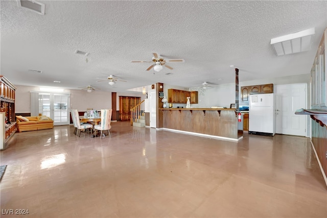 interior space with ceiling fan and a textured ceiling