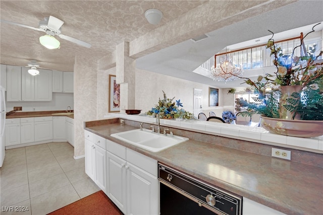 kitchen with black dishwasher, sink, ceiling fan with notable chandelier, and white cabinetry