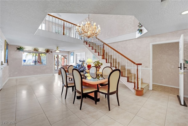 tiled dining room featuring a textured ceiling and ceiling fan with notable chandelier