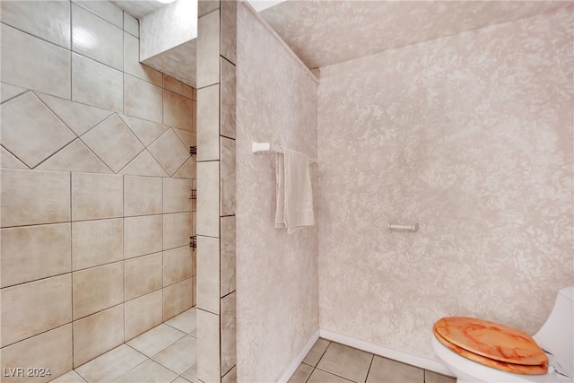 bathroom with tiled shower, tile patterned floors, and toilet