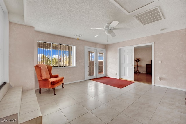 sitting room featuring a textured ceiling, plenty of natural light, tile patterned flooring, and ceiling fan