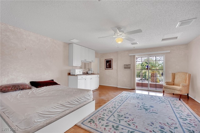 bedroom featuring a textured ceiling, light hardwood / wood-style flooring, and ceiling fan