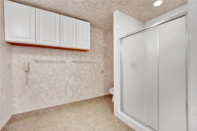 bathroom with an enclosed shower, tile patterned flooring, and toilet