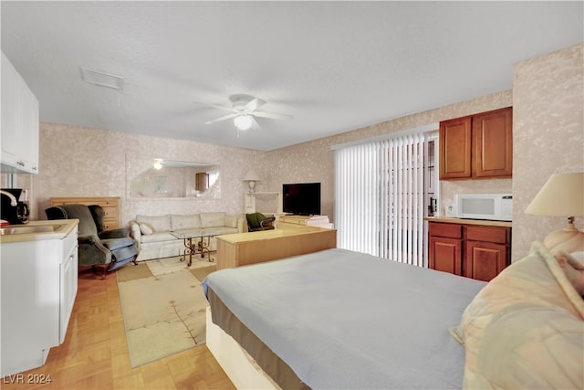 bedroom featuring ceiling fan, sink, and light parquet floors