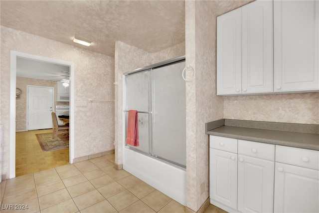 bathroom with ceiling fan, enclosed tub / shower combo, and parquet flooring