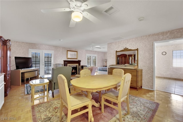 dining area with ceiling fan, french doors, and light parquet floors