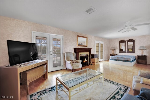 living room featuring light parquet floors, french doors, and ceiling fan