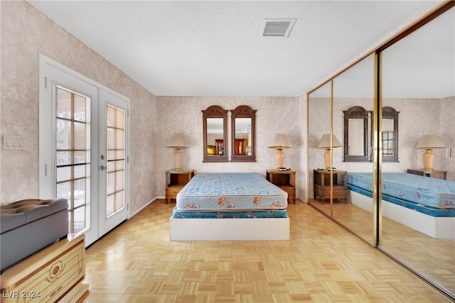 bedroom featuring french doors, a closet, multiple windows, and light parquet floors