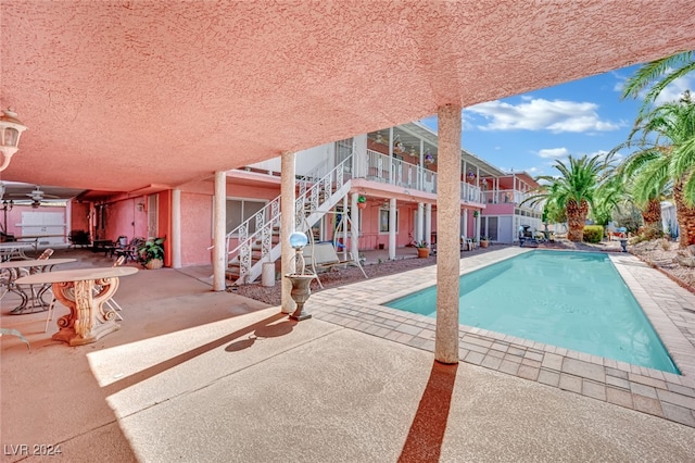 view of pool with ceiling fan and a patio