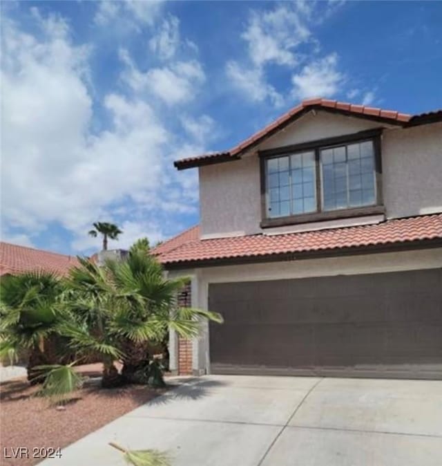 6444 Deadwood Rd, Las Vegas, NV 89108 - view of front facade with concrete driveway, a tiled roof, a garage, and stucco siding