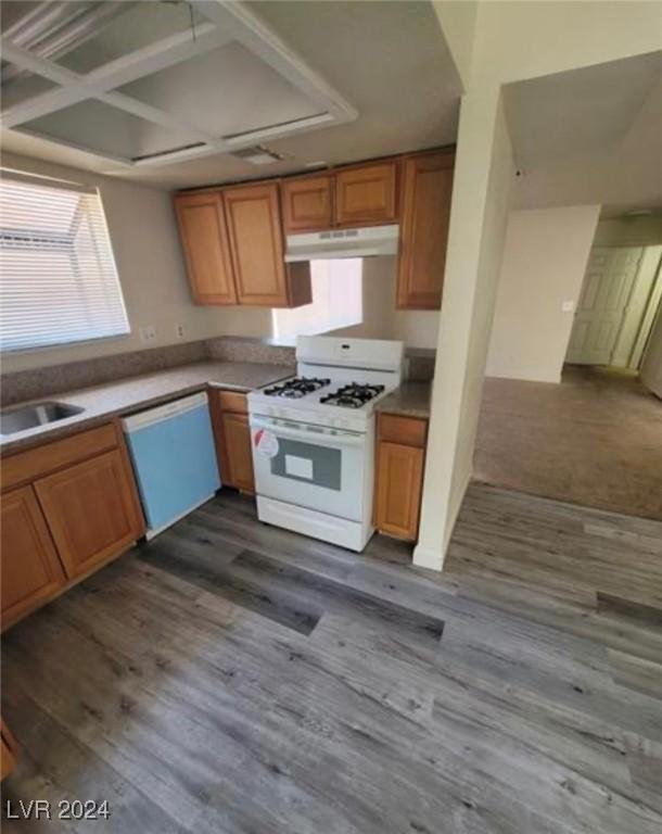 kitchen with coffered ceiling, sink, wood-type flooring, and white appliances