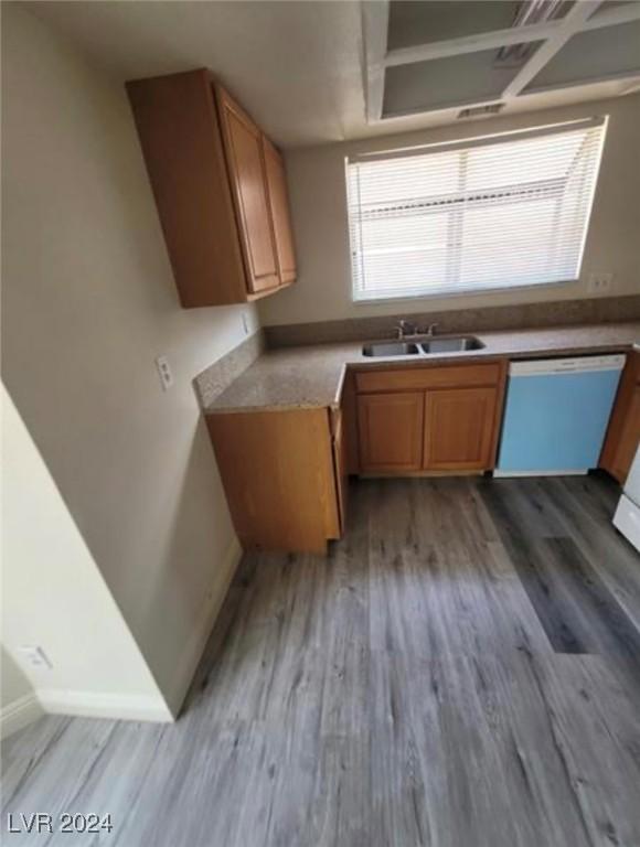 kitchen featuring sink, hardwood / wood-style flooring, and white dishwasher