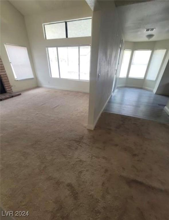 interior space featuring a brick fireplace and carpet floors