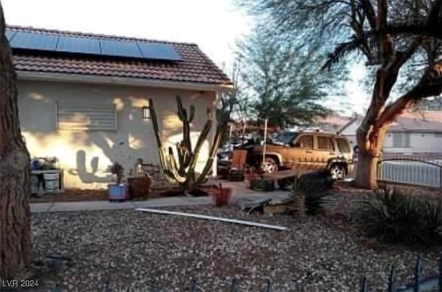 rear view of property featuring solar panels