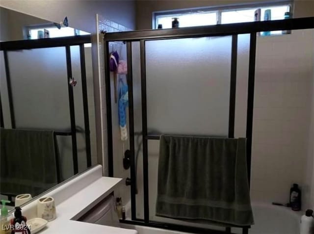 bathroom featuring vanity and bath / shower combo with glass door