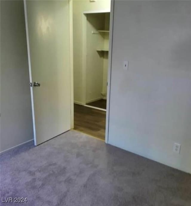 unfurnished bedroom featuring carpet floors, a walk in closet, and a closet