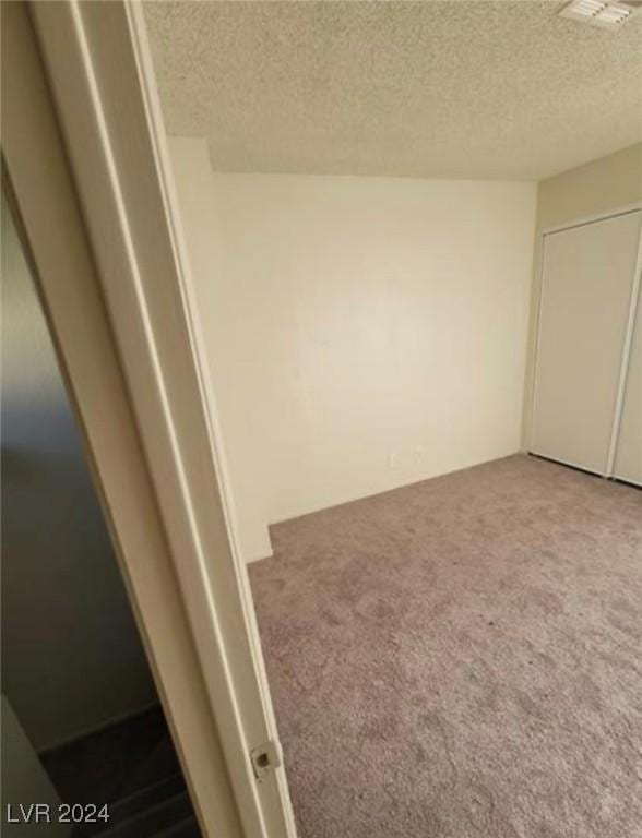 unfurnished bedroom featuring carpet flooring and a textured ceiling