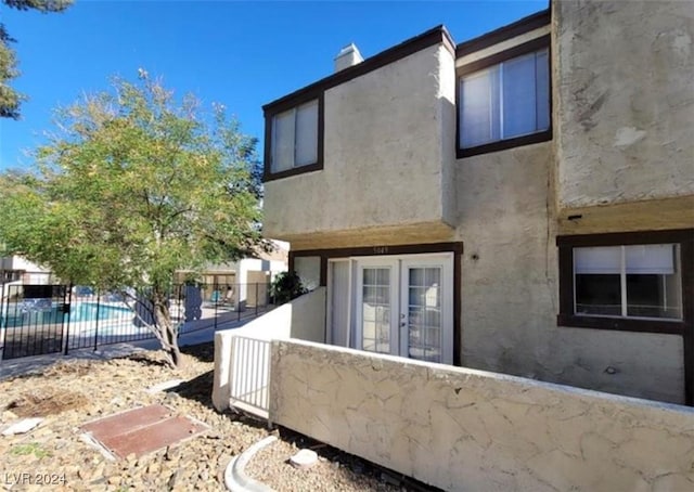 rear view of house featuring a fenced in pool