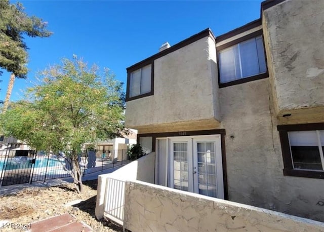 view of side of home with a fenced in pool