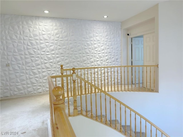 stairs with wallpapered walls and recessed lighting