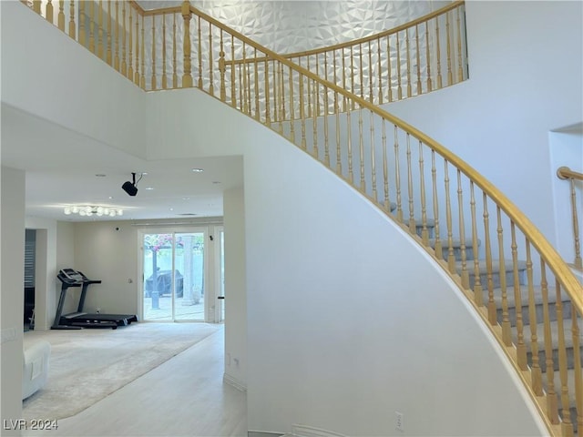 stairway with carpet flooring and a towering ceiling