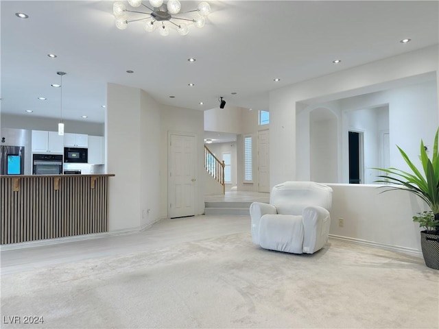 sitting room with a notable chandelier, stairway, light colored carpet, and recessed lighting