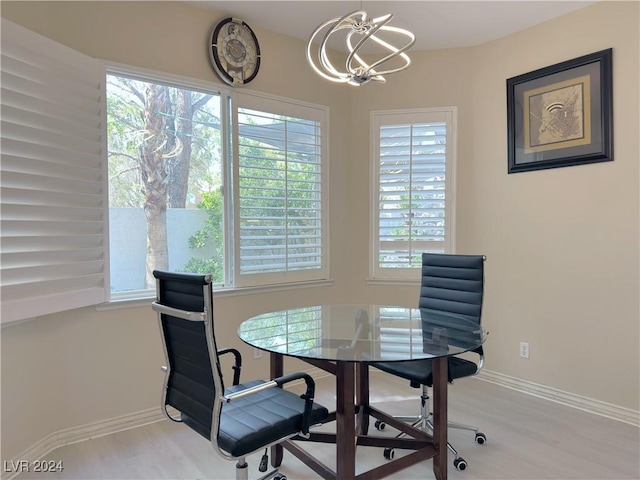 dining space featuring baseboards, a chandelier, and wood finished floors