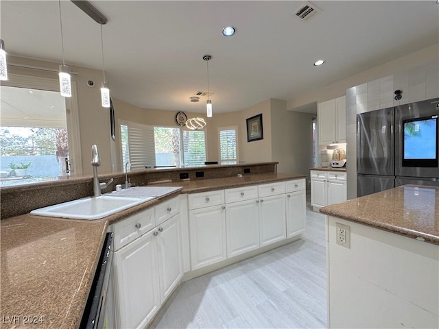 kitchen with visible vents, white cabinets, smart refrigerator, pendant lighting, and a sink