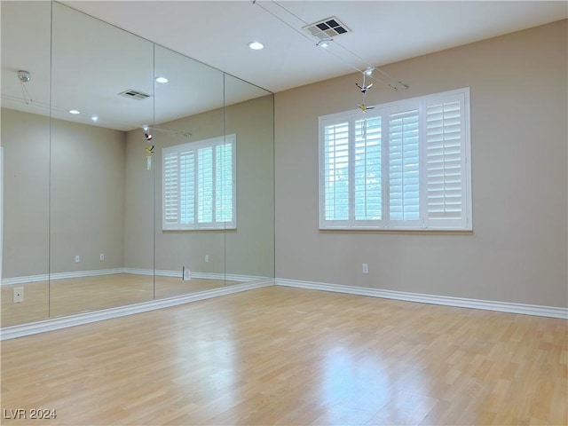 empty room with light wood finished floors, baseboards, visible vents, and recessed lighting