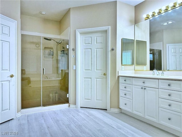 full bathroom with baseboards, wood finished floors, vanity, and a shower stall